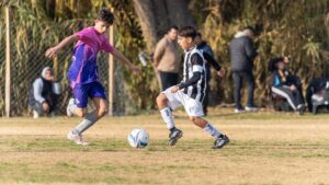 Two youth soccer players contest the ball during an outdoor match